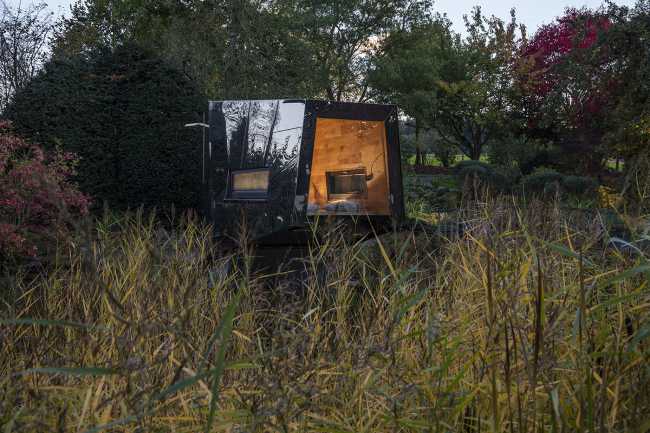 Floating Sculpted Space. The bronze colored facade elegantly reflects the environment