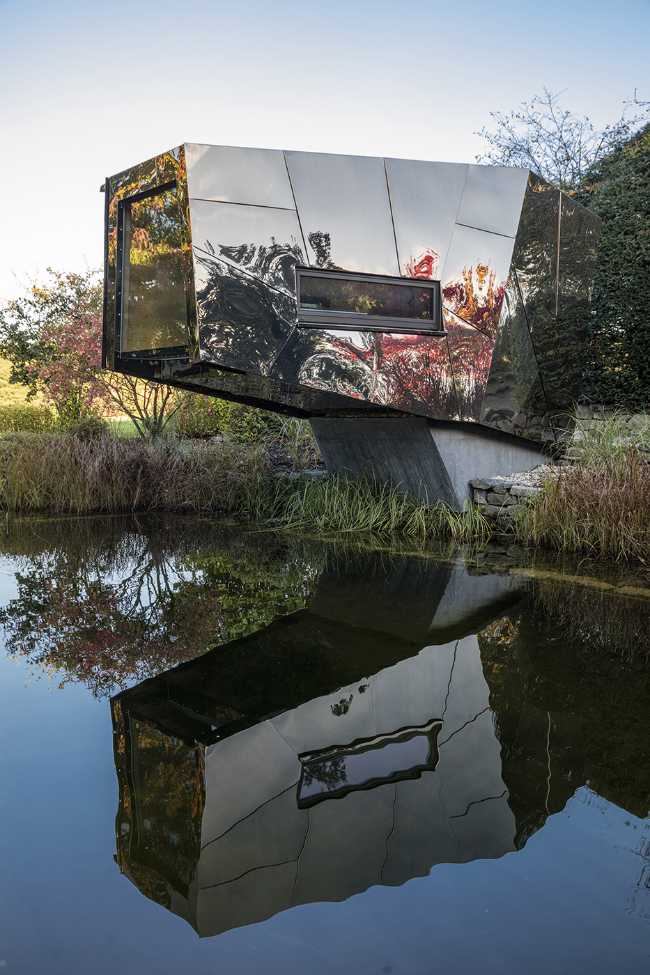 Floating Sculpted Space. The bronze colored facade elegantly reflects the environment