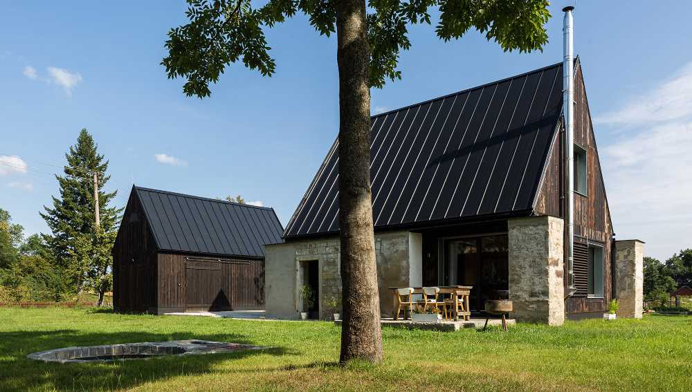 The old barn gives way to a small wooden house. Monumental granite walls preserved