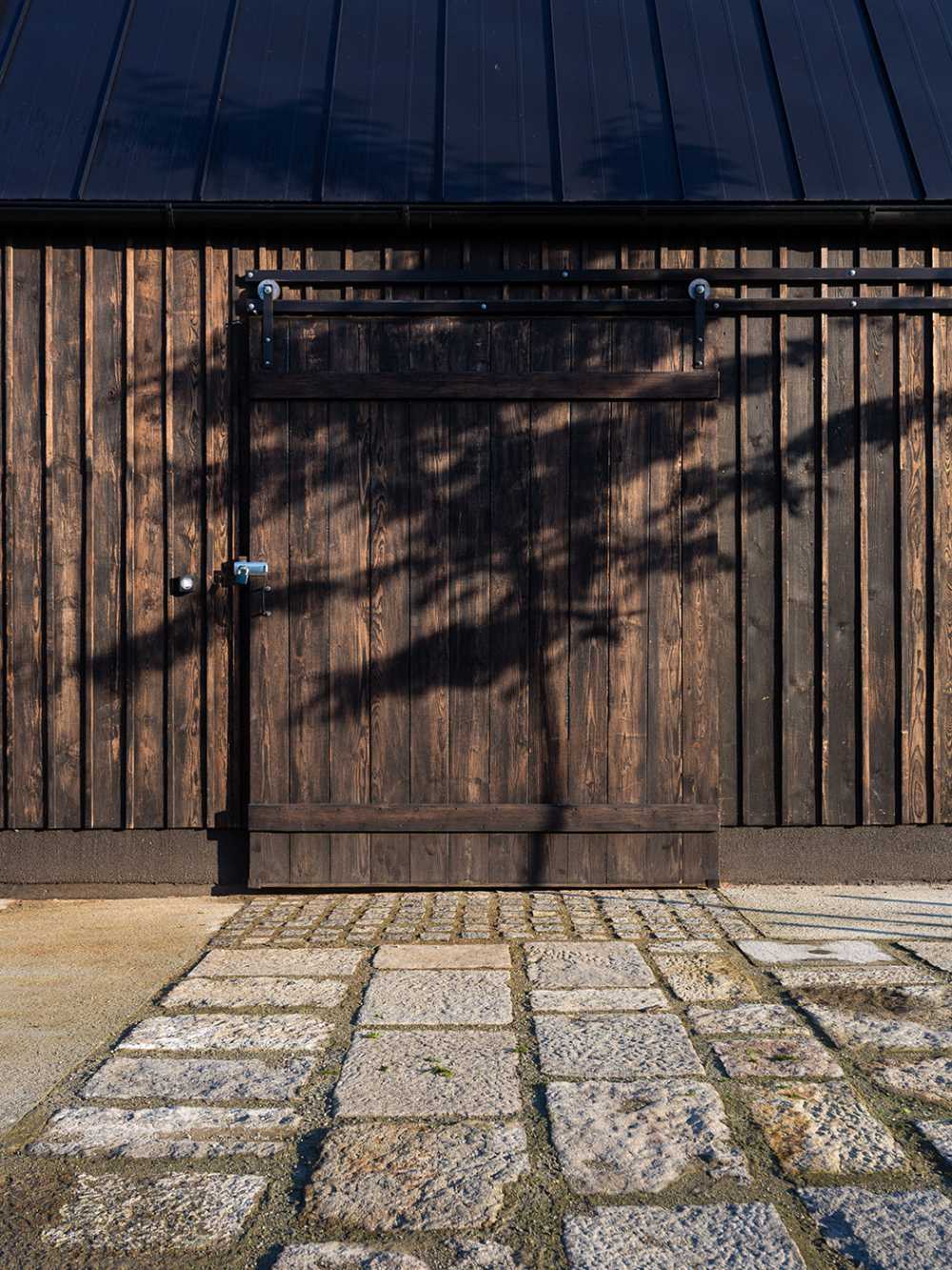 The old barn gives way to a small wooden house. Monumental granite walls preserved