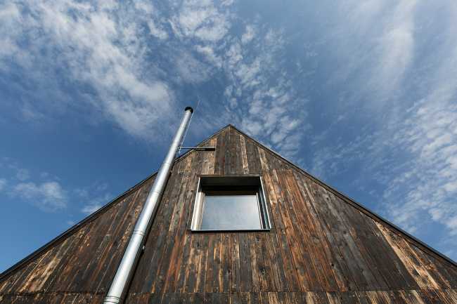 The old barn gives way to a small wooden house. Monumental granite walls preserved