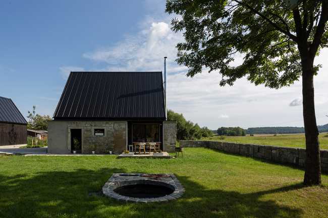 The old barn gives way to a small wooden house. Monumental granite walls preserved