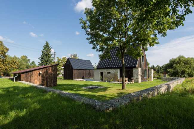 The old barn gives way to a small wooden house. Monumental granite walls preserved