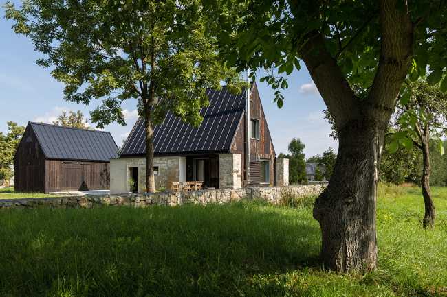 The old barn gives way to a small wooden house. Monumental granite walls preserved
