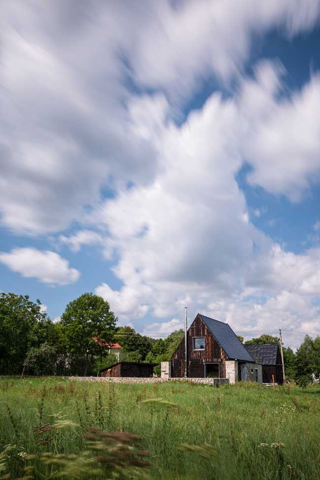 The old barn gives way to a small wooden house. Monumental granite walls preserved