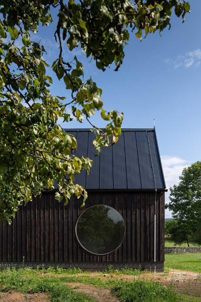 The old barn gives way to a small wooden house. Monumental granite walls preserved