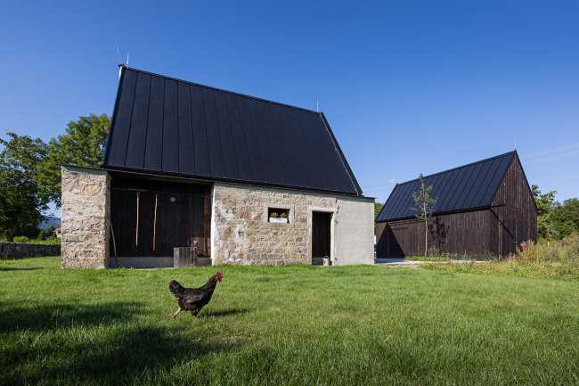 The old barn gives way to a small wooden house. Monumental granite walls preserved