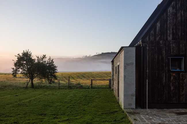 The old barn gives way to a small wooden house. Monumental granite walls preserved