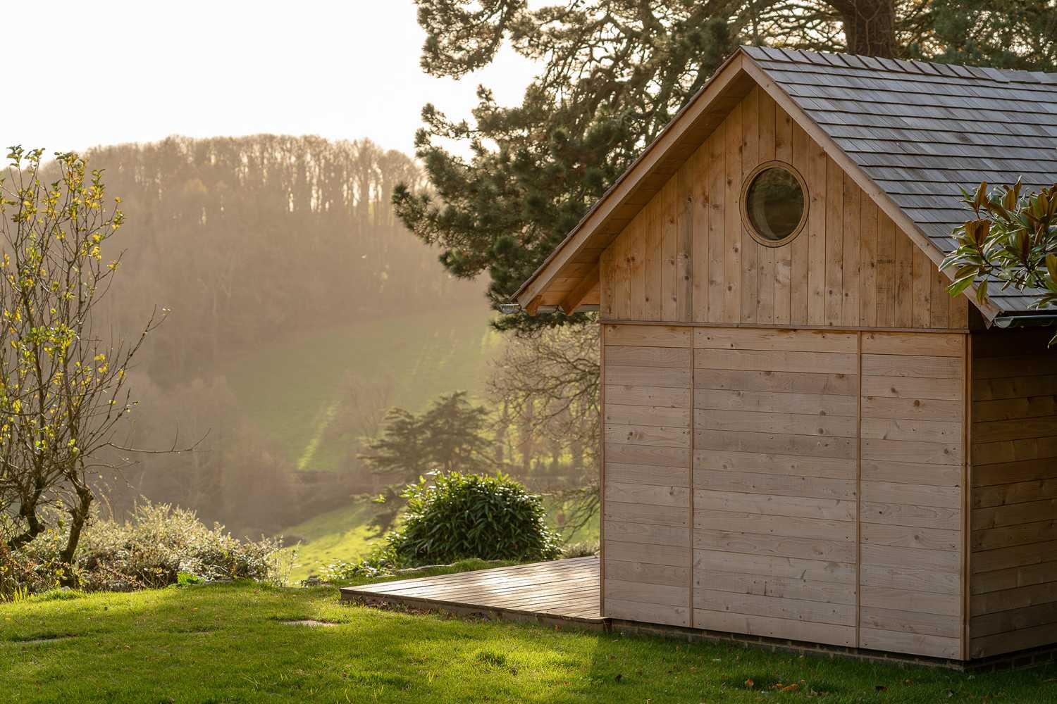 Ambientes para la relajación y la convivencia. Una cabaña de cedro reaviva el jardín de la casa de vacaciones