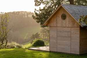 Ambiances pour la détente et le partage. Une cabane en cèdre ravive le jardin de la maison de vacances.