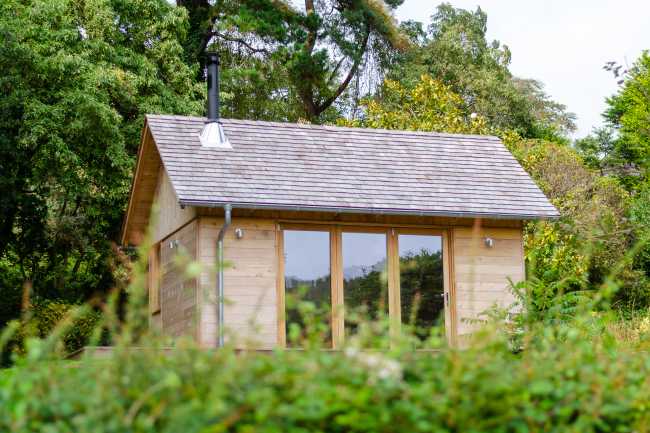 Ambiances pour la détente et le partage. Une cabane en cèdre ravive le jardin de la maison de vacances.