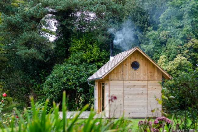 Ambiances pour la détente et le partage. Une cabane en cèdre ravive le jardin de la maison de vacances.
