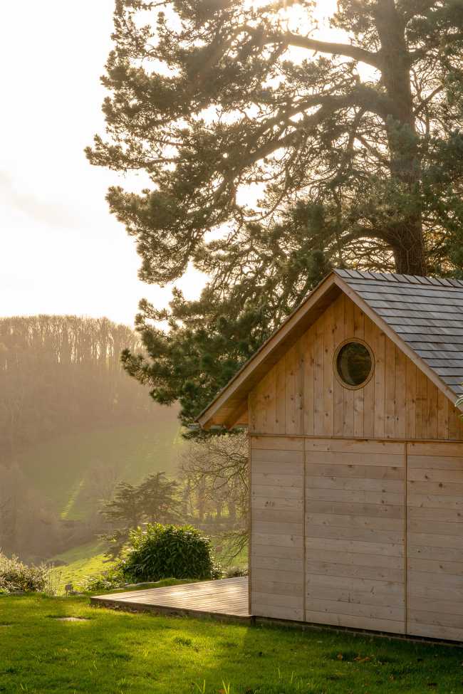 Ambiances pour la détente et le partage. Une cabane en cèdre ravive le jardin de la maison de vacances.