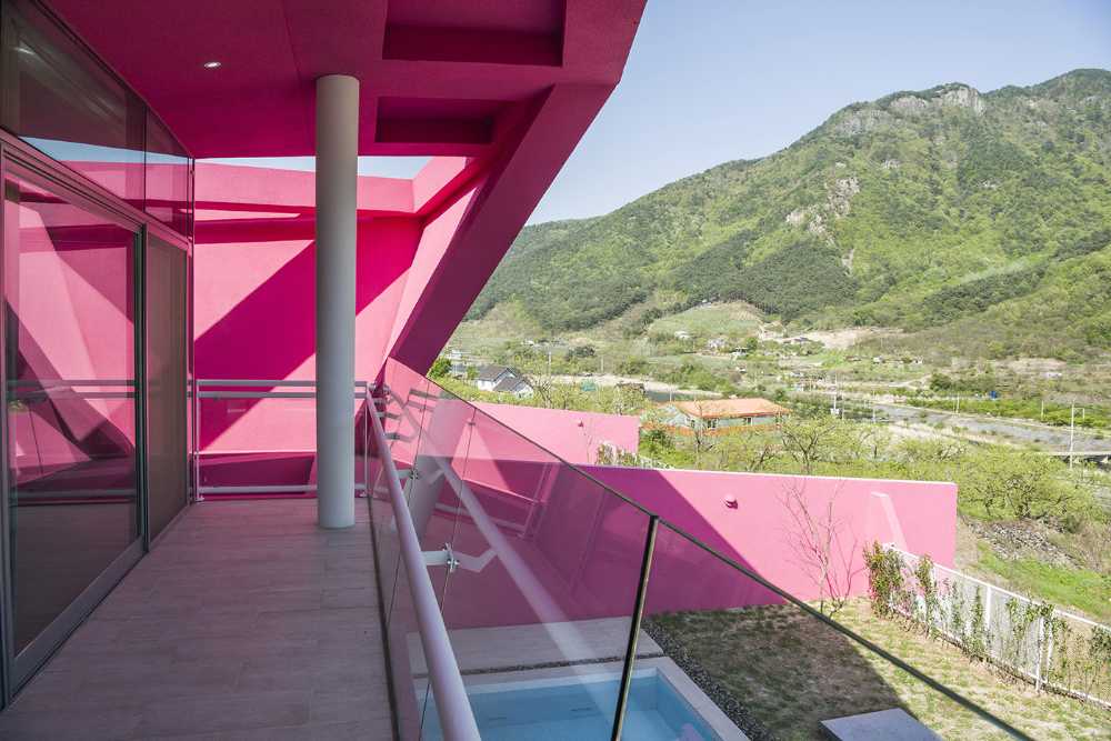 Villa de tonos rosas entre verdes colinas. Los muros circundantes enmarcan la espectacular vista