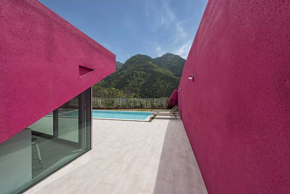 Villa de tonos rosas entre verdes colinas. Los muros circundantes enmarcan la espectacular vista