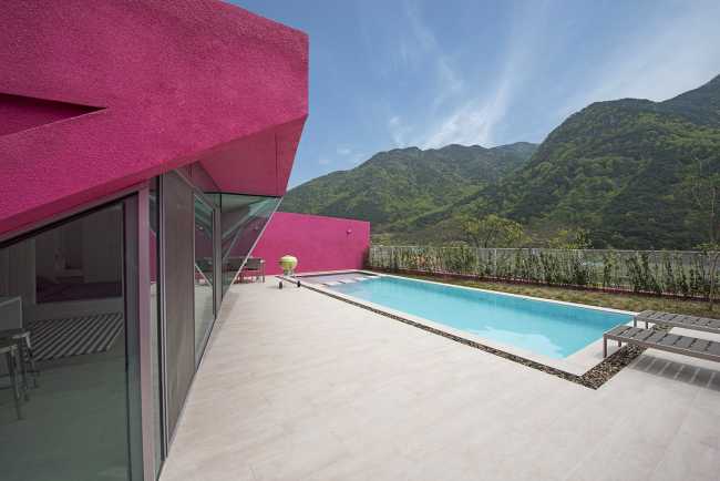 Villa de tonos rosas entre verdes colinas. Los muros circundantes enmarcan la espectacular vista