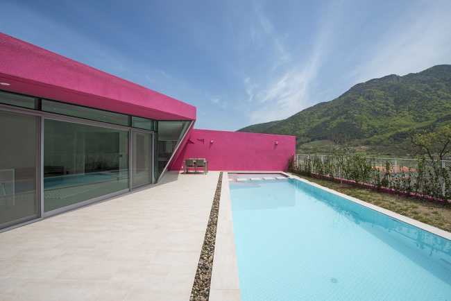 Villa de tonos rosas entre verdes colinas. Los muros circundantes enmarcan la espectacular vista