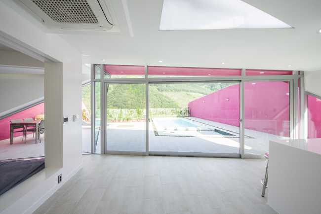 Villa de tonos rosas entre verdes colinas. Los muros circundantes enmarcan la espectacular vista