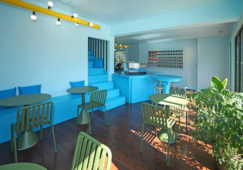 Tipico Cafè di New York. Tavoli di recupero formano bancone blu che massimizza le interazioni sociali