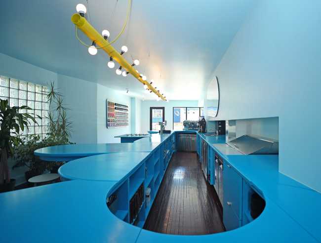 Tipico Cafè di New York. Tavoli di recupero formano bancone blu che massimizza le interazioni sociali