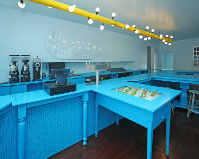 Tipico Cafè di New York. Tavoli di recupero formano bancone blu che massimizza le interazioni sociali