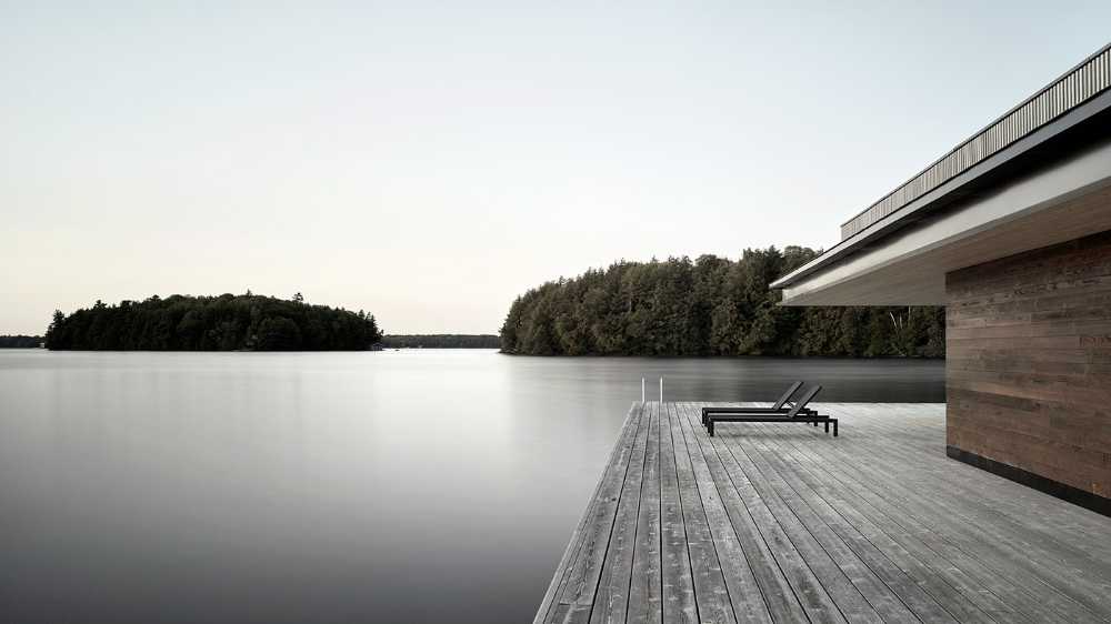 Une enclume rocheuse abrite un chalet en bois. Maison de bateau au bord d'un lac