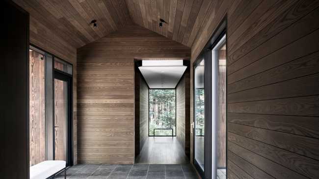 Une enclave rocheuse abrite un chalet en bois. Remise pour bateaux sur les rives d'un lac.