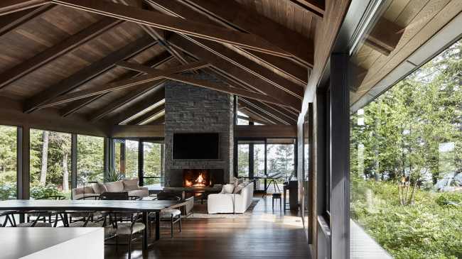 Une enclave rocheuse abrite un chalet en bois. Remise pour bateaux sur les rives d'un lac.