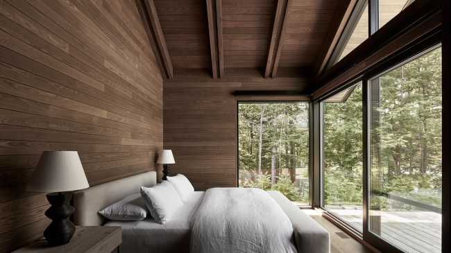 Une enclave rocheuse abrite un chalet en bois. Remise pour bateaux sur les rives d'un lac.