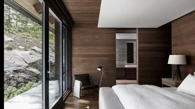 Une enclave rocheuse abrite un chalet en bois. Remise pour bateaux sur les rives d'un lac.