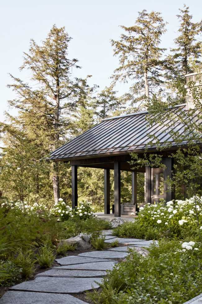 Une enclave rocheuse abrite un chalet en bois. Remise pour bateaux sur les rives d'un lac.