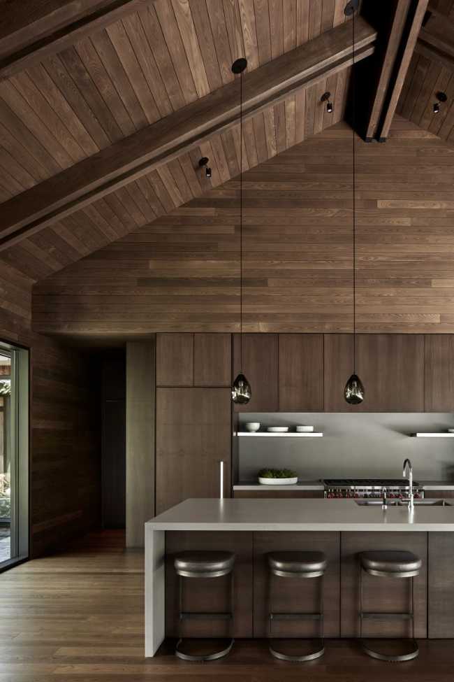 Une enclave rocheuse abrite un chalet en bois. Remise pour bateaux sur les rives d'un lac.