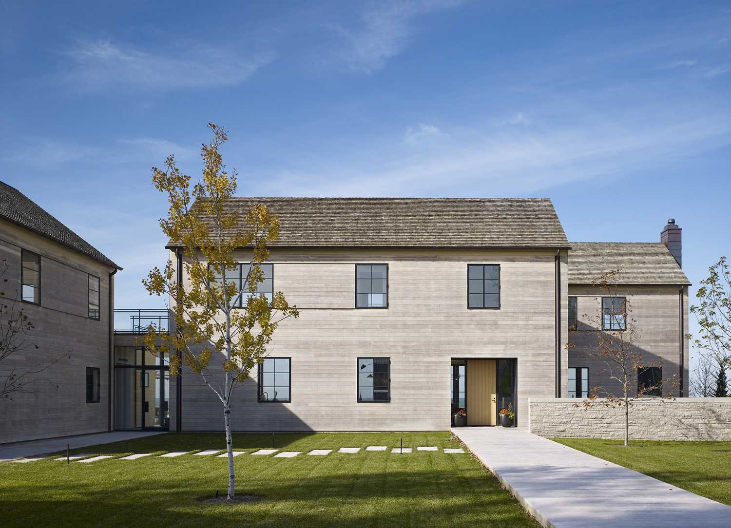 St. Joseph Residence: group of vernacular volumes rest on a green lawn overlooking the lake