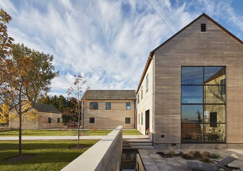 St. Joseph Residence: group of vernacular volumes rest on a green lawn overlooking the lake