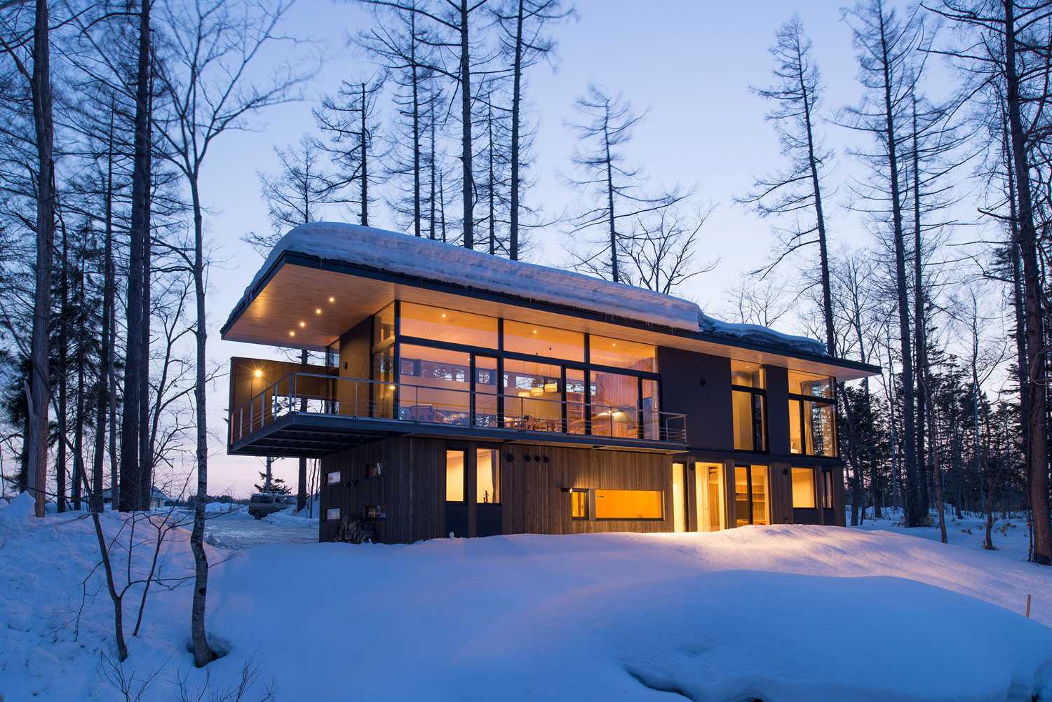 Architectural dialogue between cedar and metal for the Hiyoku home, a backdrop of Japan's snow-capped mountains