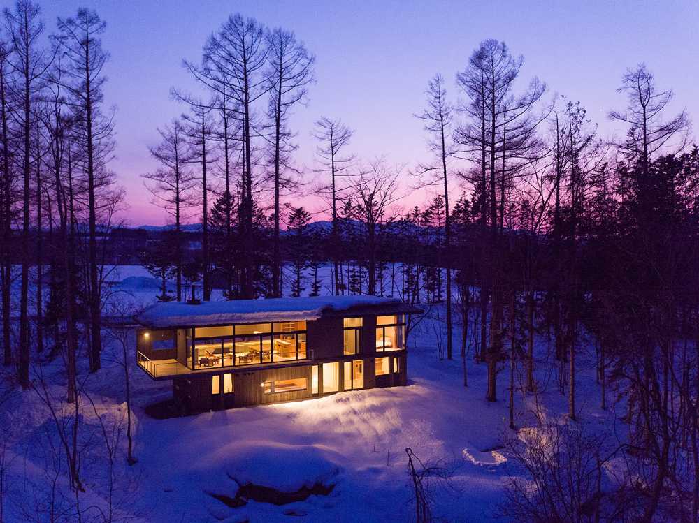 Architectural dialogue between cedar and metal for the Hiyoku home, a backdrop of Japan's snow-capped mountains