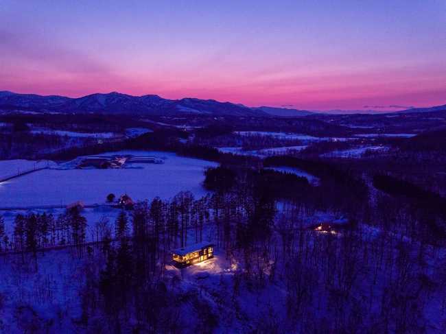 Dialogue architectural entre le cèdre et le métal pour la maison Hiyoku, cadre des montagnes enneigées du Japon