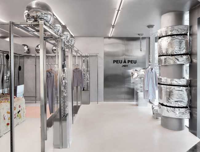 Futuristic sportswear shop: the Peu à Peu design displays the principles of fitness with robots and moving reflective spheres