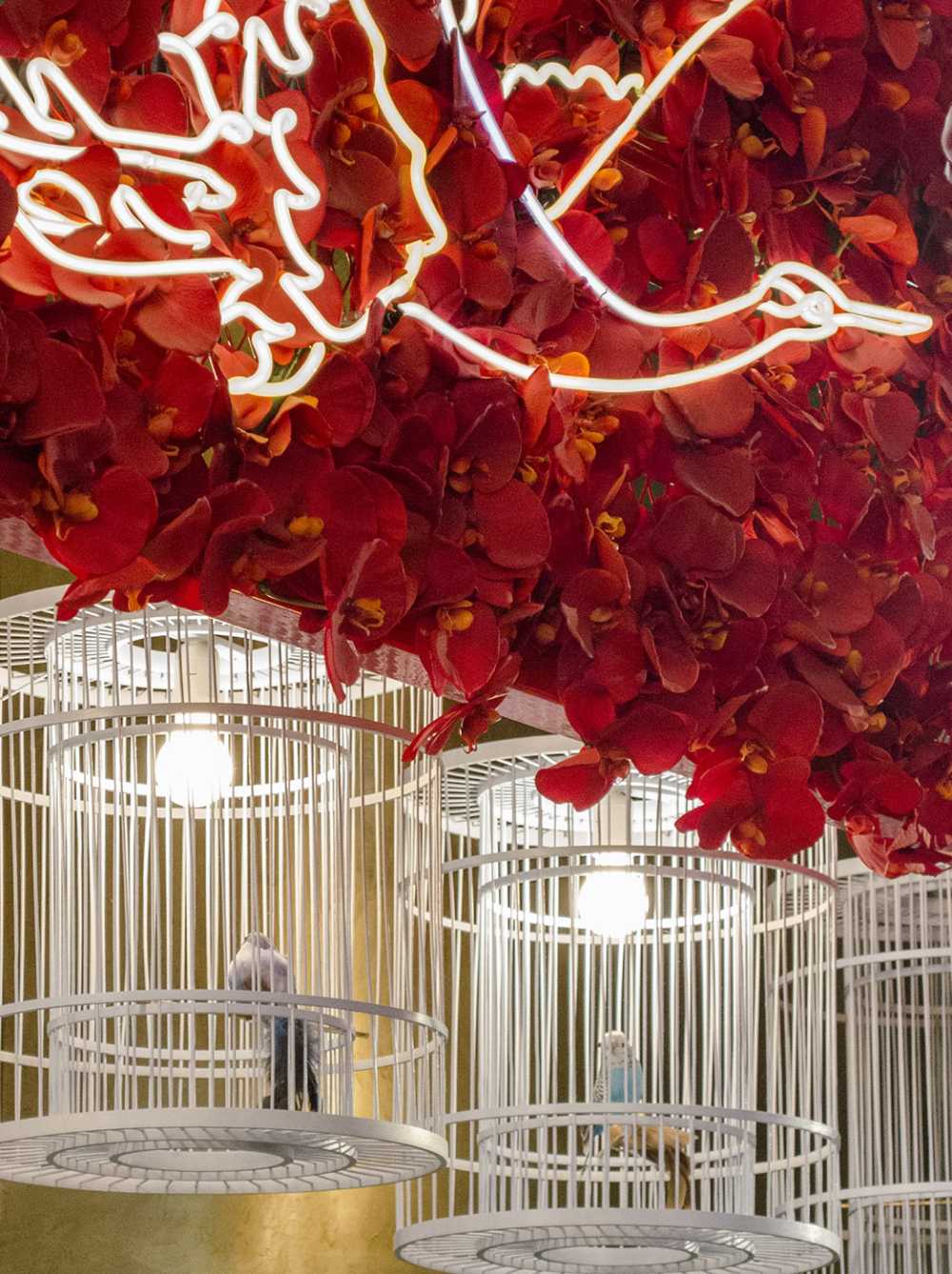 Ho Lee Chix. Fiori rossi e neon a forma di gru per una bancarella di street food