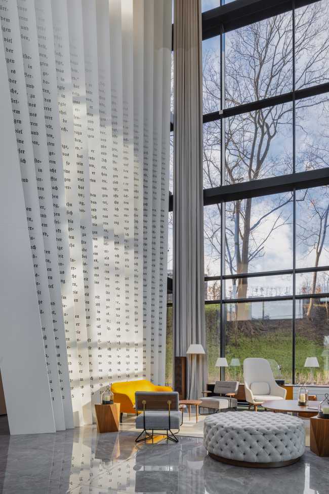 Enormi libri in legno creano lo spazio per la Lobby del Philosophers Residence in Lettonia