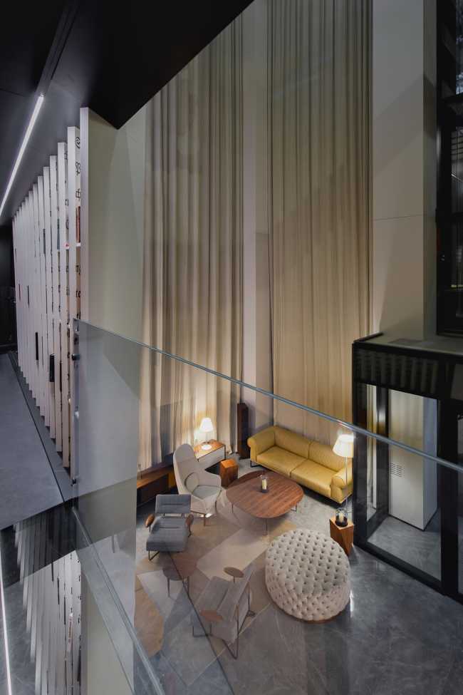 Enormi libri in legno creano lo spazio per la Lobby del Philosophers Residence in Lettonia