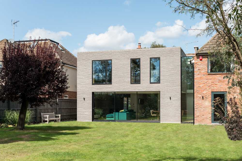 Long Brick House. A stone brick housing connected to the existing building by a glazed