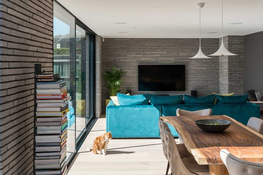 Long Brick House. Une boîte de briques en pierre reliée à la structure préexistante par un couloir vitré