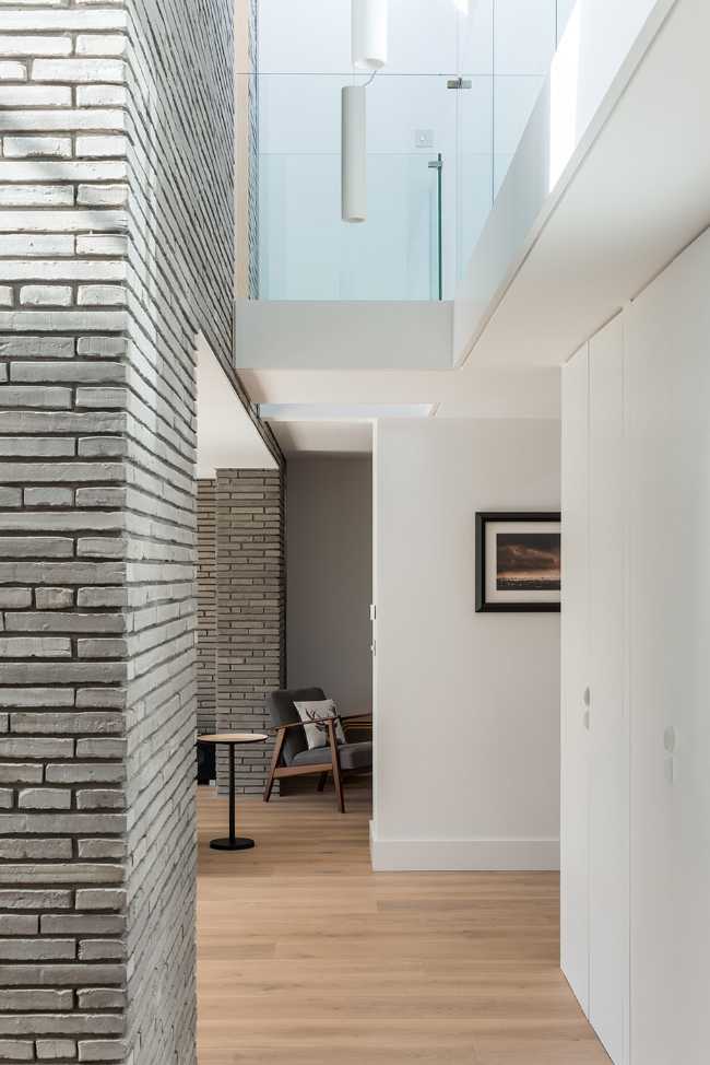 Long Brick House. Une boîte de briques en pierre reliée à la structure préexistante par un couloir vitré