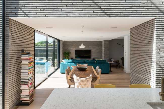 Long Brick House. Une boîte de briques en pierre reliée à la structure préexistante par un couloir vitré