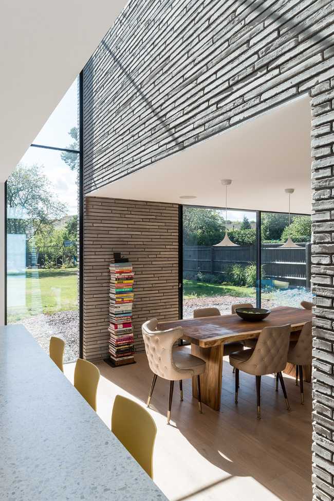 Long Brick House. Une boîte de briques en pierre reliée à la structure préexistante par un couloir vitré