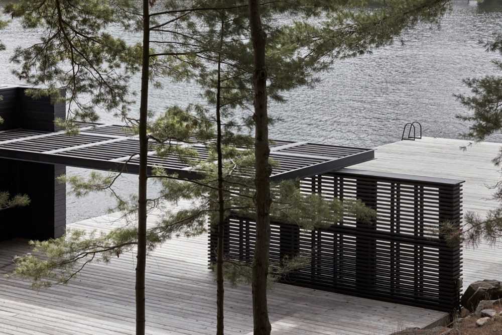Charred Wood Boathouse. Parallel wooden planes build an ethereal space on the lakeshore