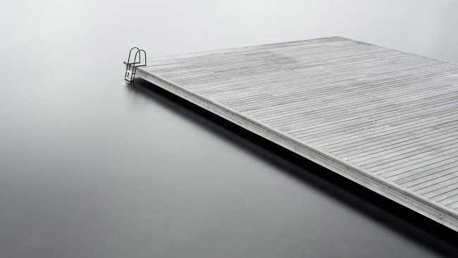 Boathouse in legno carbonizzato. Piani paralleli in legno costruiscono uno spazio etereo sulla riva del lago