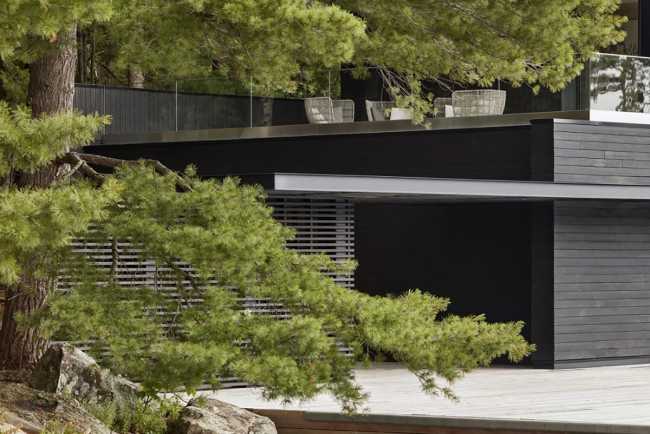 Boathouse in legno carbonizzato. Piani paralleli in legno costruiscono uno spazio etereo sulla riva del lago