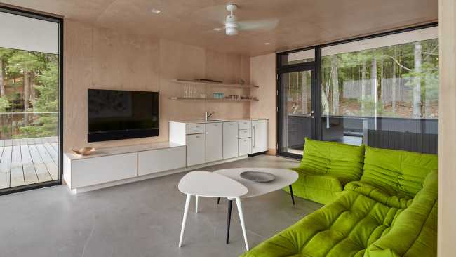 Boathouse in legno carbonizzato. Piani paralleli in legno costruiscono uno spazio etereo sulla riva del lago